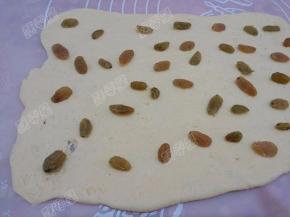 将葡萄干均匀的铺在面片上