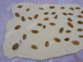 将葡萄干均匀的铺在面片上