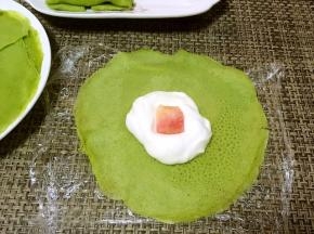 在面片中间放入适量的淡奶油跟水果块，本来准备放芒果的，结果发现芒果坏了，就用了甜桃
