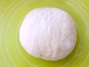 将面团整理成圆形，放盆内盖保鲜膜发酵至两倍大