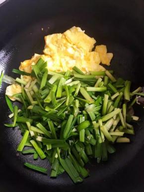 将炒好的鸡蛋推至一边，用余油将韭菜炒软，与鸡蛋混合