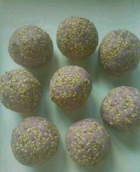 然后把豆沙包入紫薯里面，外面粘上一层芝麻