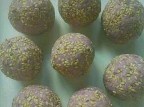 然后把豆沙包入紫薯里面，外面粘上一层芝麻
