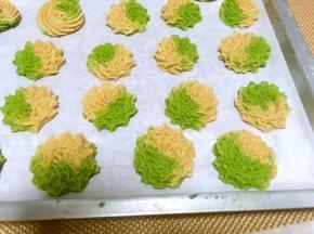 再准备一个大的裱花袋，放入8齿裱花嘴，将两个颜色的裱花袋均匀的装入大裱花袋内，垂直挤出大小均匀的花朵