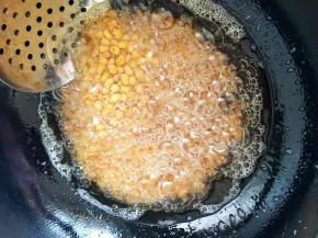 6、开大火升高油温后倒入黄豆复炸