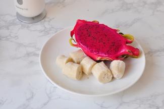 将冻香蕉切段，火龙果对切划井字型备用。