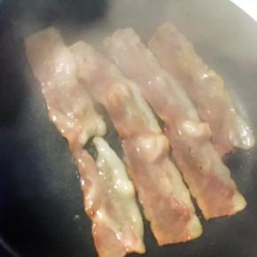 4、培根放平底锅中煎至两面金黄，边缘卷曲