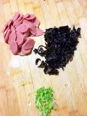 木耳去根部洗净切碎，葱段切碎，烤肠切成薄片