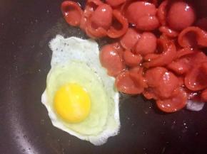 将烤肠推至锅边，用余油炒蛋，直接在锅中边炒边打散