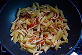 炒锅加橄榄油，放入意面，鸡丝和红椒，加入意面酱炒匀，磨入点黑椒粉，加盐调味