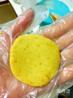 取一小块面团搓成丸子，用手心按压成饼状