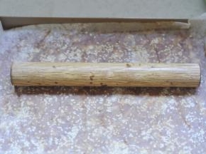 8、将擀好的肉上，刷一层蜂蜜水，撒上白芝麻，垫上油纸再用擀面杖压平，提前将烤箱预热