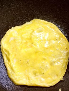 晃动锅，鸡蛋饼在锅内能滑动，翻个面，我借助刮棒帮助翻面的，千万别弄破，煎一小会熟透就可以