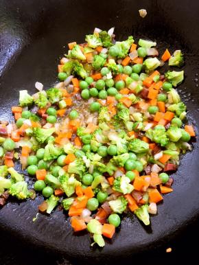 再放入腊肉、胡萝卜翻炒，最后放入青豆跟西兰花，加盐，酱油炒熟