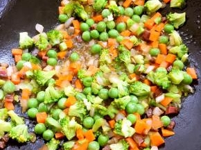 再放入腊肉、胡萝卜翻炒，最后放入青豆跟西兰花，加盐，酱油炒熟