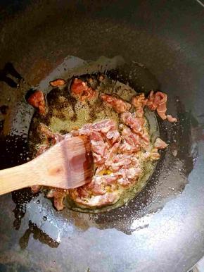 炒锅中倒油，把羊肉丝放入快速滑散。