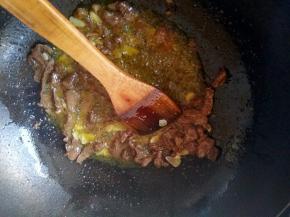 羊肉炒变色之后加入蒜片爆香，加入一点酱油，盐，再放一点孜然粒。