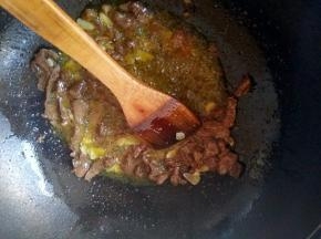 羊肉炒变色之后加入蒜片爆香，加入一点酱油，盐，再放一点孜然粒。