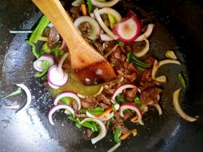 把青椒丝圆葱丝胡萝卜丝倒进锅中翻炒。