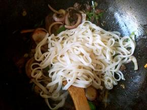 菜炒软之后下入面条，翻炒均匀。