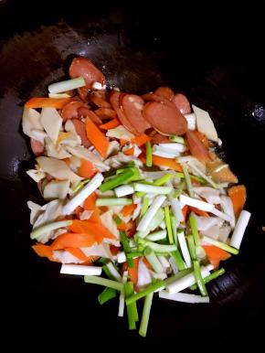 放入杏鲍菇，胡萝卜和葱段翻炒片刻！