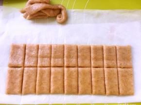 裁成方形，切成大小相同的块，裁掉的边角别丢掉，继续擀成薄片，切成块，烤箱预热180度