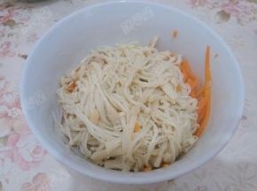 将汆烫好的胡萝卜丝、金针菇放入碗中