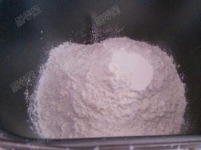 高筋面粉和奶粉放入面包桶内