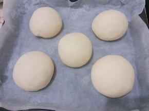 将烤盘放进烤箱，烤箱里放进一小碗温水，关上烤箱门，发酵至2倍大（约一小时）