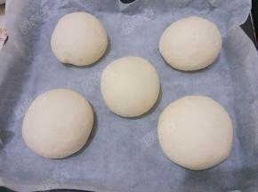 将烤盘放进烤箱，烤箱里放进一小碗温水，关上烤箱门，发酵至2倍大（约一小时）