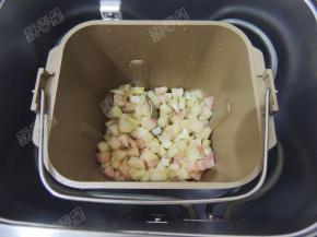 然后将桃子连同腌制出的汁液一起倒入面包桶内，加入柠檬汁