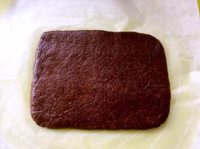 桌上铺一张油纸，放上可可面团，用擀面杖尽量擀成长方形，放一旁备用