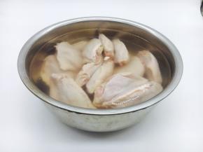 在新鲜的鸡翅背部划两刀，放在清水里浸泡30分钟，挤一挤血水，洗干净备用。