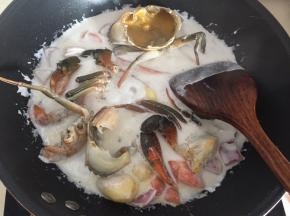 然后放入青蟹和鸡蛋液翻拌均匀盖上锅盖煮沸后转小火炖10分钟