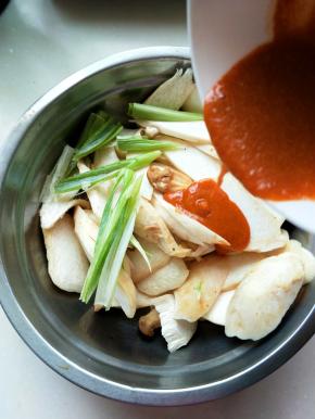 将切片的杏鲍菇放入盆里，加入葱段，倒入蜜汁调料，