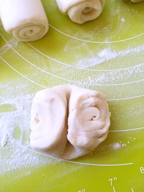 松弛好的牛舌卷，从中间压一下，再压扁，擀成2毫米厚的圆饼