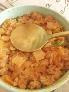 取一个圆形小碗，把米饭放进去，借助勺子压紧