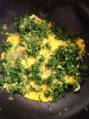 7、将荠菜平铺开，将打散的蛋液倒在上面，炒熟即可