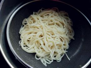 挂面在热水里煮至六七成熟，倒在筛网里，用冷水冲洗，沥净水分备用