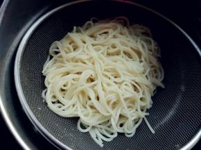 挂面在热水里煮至六七成熟，倒在筛网里，用冷水冲洗，沥净水分备用