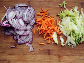 煮面条的同时，将洋葱、胡萝卜、卷心菜切丝