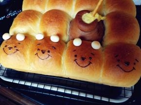 脱模晾凉的同时，用隔水融化的黑巧克力画出维尼熊的五官，另在头部挤少许巧克力，粘住用来做耳朵的旺仔小馒头。