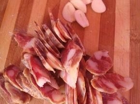 把腊肠切成薄片，(也可以放入锅中提前蒸个十分钟)。