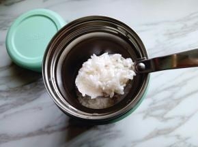 5分钟后将焖烧罐的水倒掉，加入提前泡好的大米。