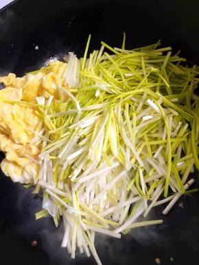 4、	将炒好的鸡蛋推至一边，用余油将蒜黄炒软，与鸡蛋混合，加盐调味即可