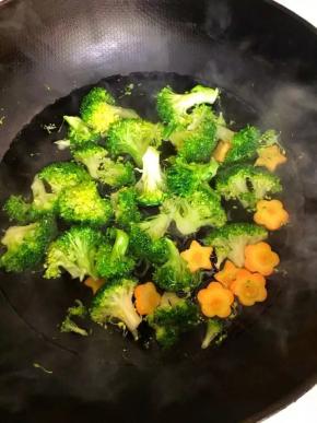 4、	锅中放适量水，烧开后将西兰花和胡萝卜放入焯水