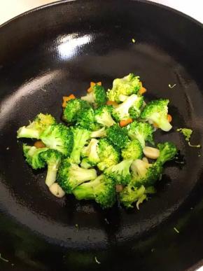 6、	锅中倒入油，油热至7成时下蒜片翻炒出香味，倒入沥干水分的的西兰花和胡萝卜翻炒