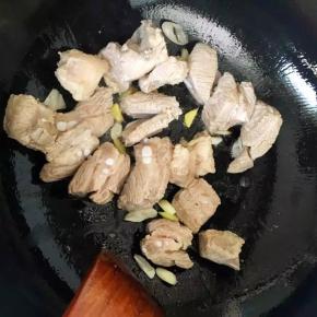 5、倒入排骨翻炒至表面变黄