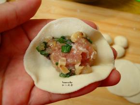 把饺子馅放入饺子皮中，包出自己喜欢的饺子形状；
