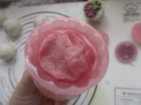 把模具先用红色的面团沾在模具上，再放入包好的紫薯球。